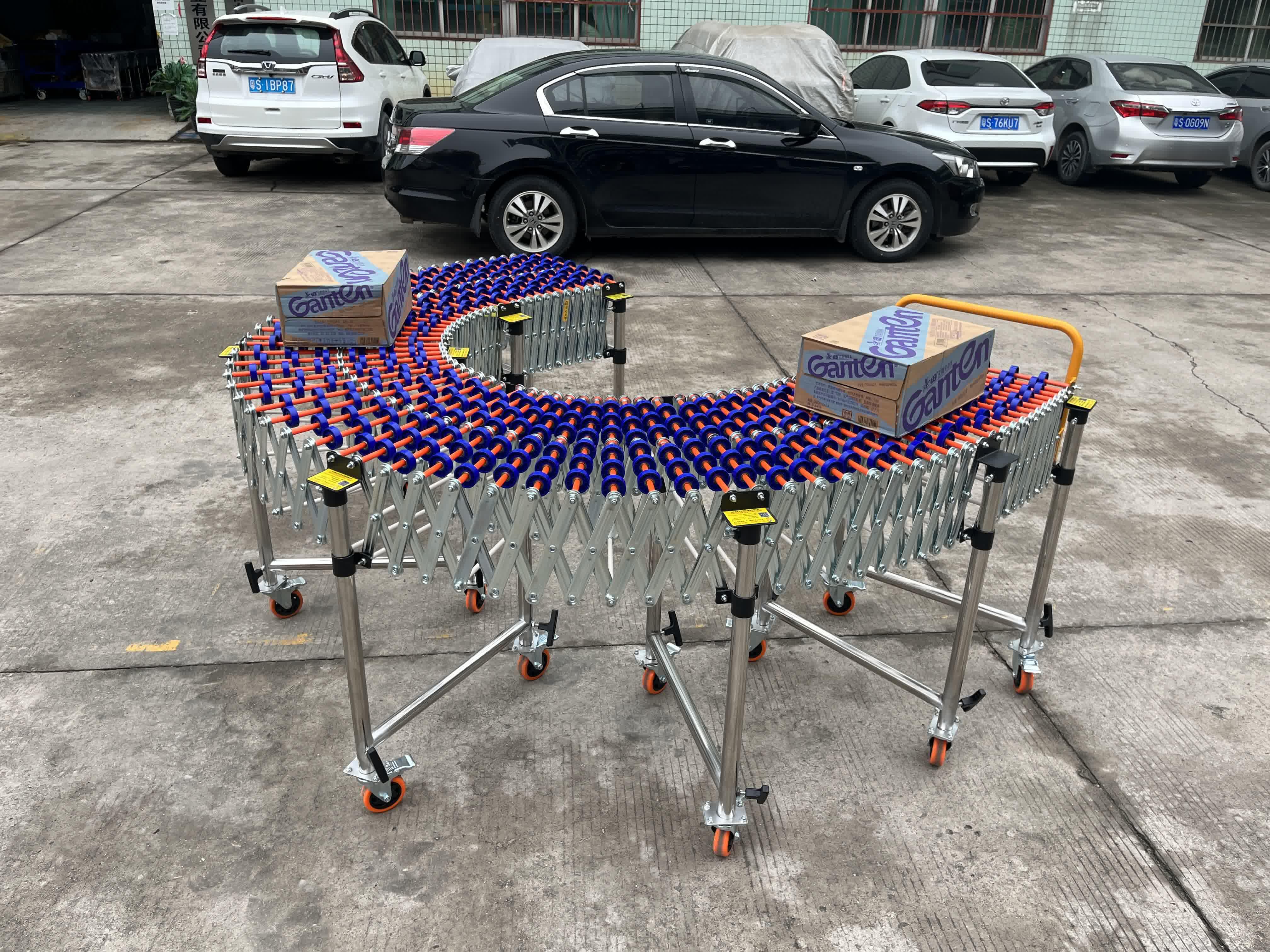 Gravity Skate Wheel Conveyor conveying bottled water in boxes